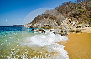 Paradise sand beach with turquoise blue water in Huatulco, Oaxaca, Mexico