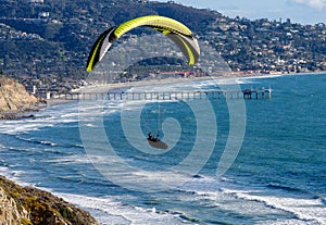 Paraglider above Pacific ocean with Scripps Institution of Oceanography Pier in background, La Jolla, CA. photo