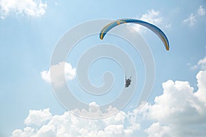 Paraglider in the blue sky, big blue clouds