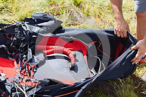 Paraglider checking harness before flight.