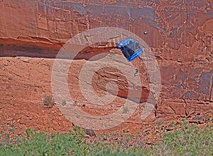 Paraglider drops to the ground along a canyon in Arches National Park.