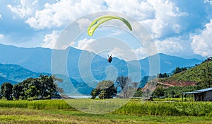 Paraglider flies over a meadow, Pokhara, Nepal