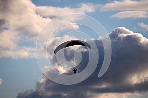 Paraglider flies in stormy skies