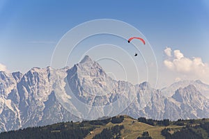 Paraglider flyes over mountains in Alps, Austria