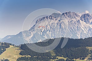 Paraglider flyes over mountains in Alps, Austria