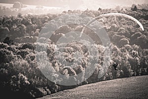 Paraglider flying above belgian countryside