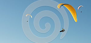 Paraglider flying in a blue sky