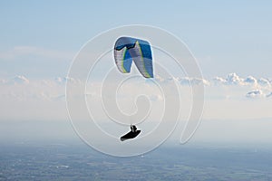 Paraglider flying in the blue sky. Italian Alps. Piedmont. Italy