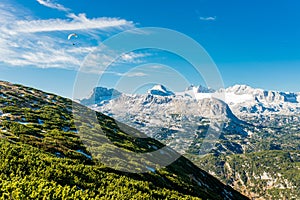 Paraglider flying in blue sky