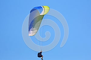 Paraglider flying in a blue sky