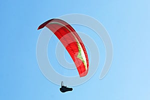 Paraglider flying in a blue sky