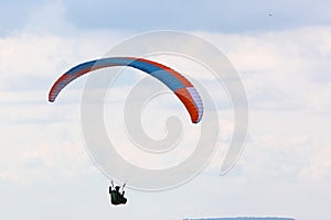 Paraglider flying in a cloudy sky