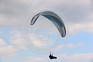 Paraglider flying in a cloudy sky