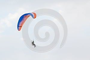 Paraglider flying over a blue sky