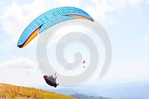 Paraglider is flying over the high mountains