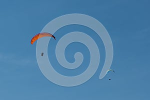 Paraglider flying over mountains in Italy