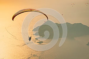 Paraglider flying over the Oludeniz sea at sunset. Holiday and Summer background