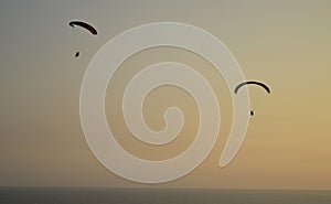 Paraglider flying over a sunset without people in the Pacific Ocean