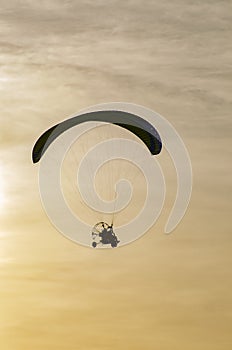 Paraglider flying in the sky at sunset