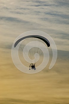 Paraglider flying in the sky at sunset