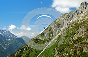 Paraglider flys in the mountains