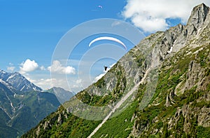 Paraglider flys in the mountains photo