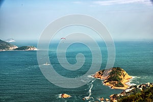 A paraglider glides over Shek O from the Dragon`s Back Trail in Shek O Country Park, Hong Kong