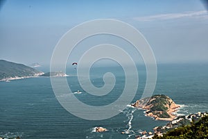 A paraglider glides over Shek O from the Dragon`s Back Trail in Shek O Country Park, Hong Kong