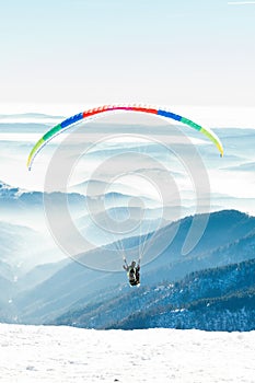 Paraglider launched into air from a mountain peak