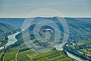 Paraglider over Moselle River bend near Bremm town, Germany