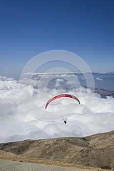 Paraglider silhouett against a cloudy blue sky.