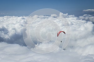 Paraglider silhouett against a cloudy blue sky