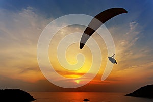 Paraglider silhouette against the background of the sunset sky