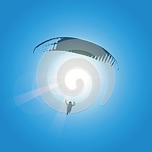 Paraglider silhouette in blue sunny sky