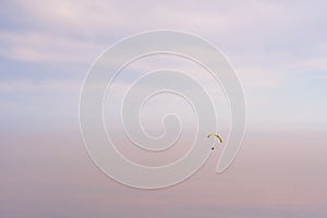 Paraglider silhouette flying on blue sky background. Nature landscape.