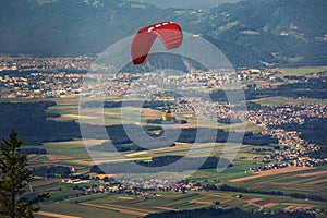 Paraglider in the sky. Farming fields and city in lowlands