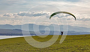 Paraglider starts flight from the hill. Extreme sports activity.