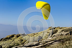 Paraglider takes off from mountain peak