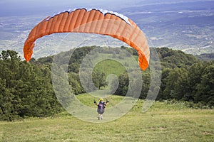 Paraglider taking off from the edge of the mountain