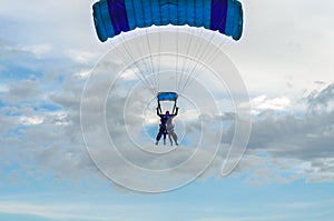 Paraglider tandem fly against the blue sky.