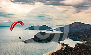 Paraglider tandem flying over the Oludeniz Beach and bay at idyllic atmosphere. Oludeniz, Fethiye, Turkey. Lycian way.