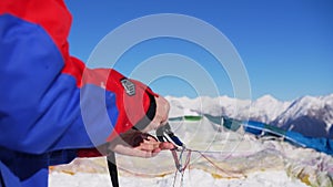 paraglider unravels paragliding slings in winter against of mountains