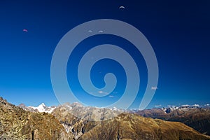 Paragliders enjoying majestic view to Swiss Alps from the top of