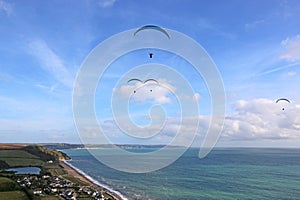 Paragliders flying above Beesands in Devon