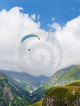 Paragliders flying with a paramotors with beautiful mountain view against blue cloudy sky