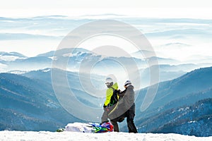 Paragliders getting ready to launch from snowy slope of a mountain