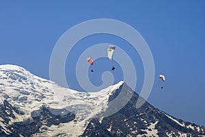 Paragliders looking for thermals amongst the snow caps of the Monte Blanc Massif, Chamonix