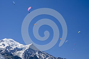 Paragliders looking for thermals amongst the snow caps of the Monte Blanc Massif, Chamonix,