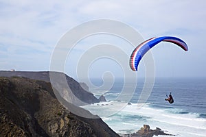 Paragliding above the ocean at Castelejo beach in Portugal