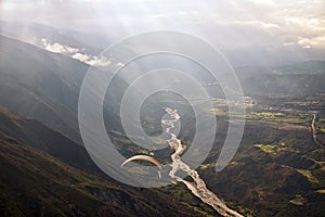 Paragliding among clouds above mountain range